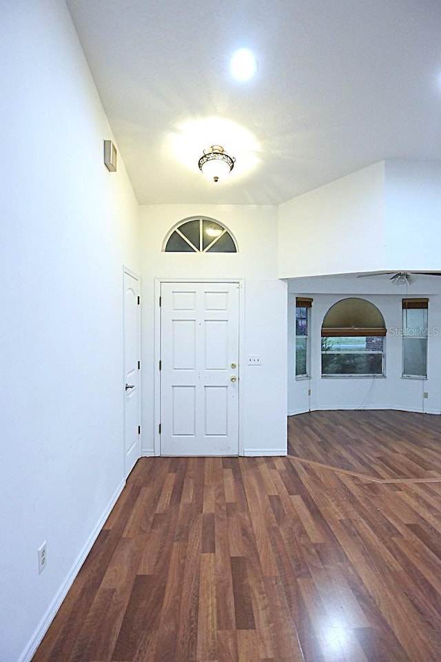 foyer entrance featuring a fireplace, baseboards, and wood finished floors