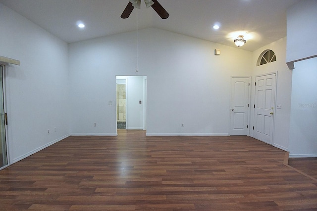 spare room featuring dark wood-style floors, high vaulted ceiling, a ceiling fan, and baseboards