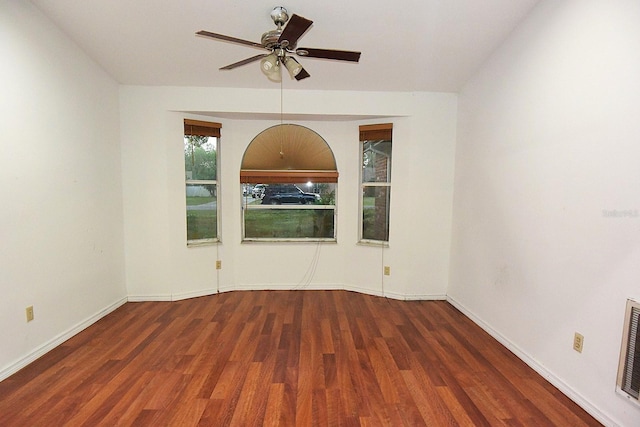 spare room featuring ceiling fan, wood finished floors, visible vents, and baseboards