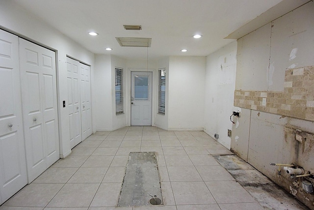 interior space with recessed lighting, baseboards, and light tile patterned flooring