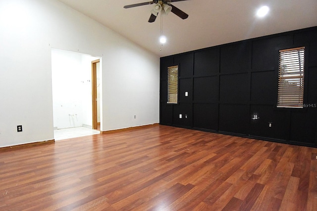 empty room featuring ceiling fan, high vaulted ceiling, and wood finished floors