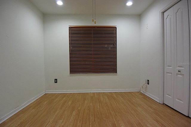 empty room with recessed lighting, light wood-type flooring, and baseboards