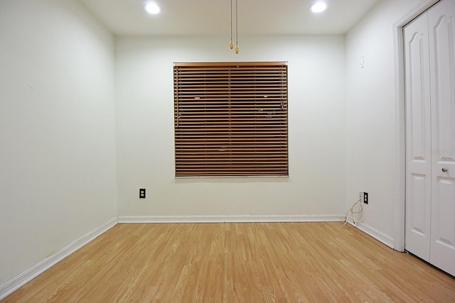 spare room featuring light wood finished floors, baseboards, and recessed lighting