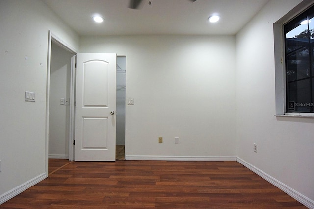 empty room with baseboards, wood finished floors, and recessed lighting