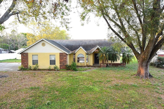 single story home featuring a front lawn and brick siding