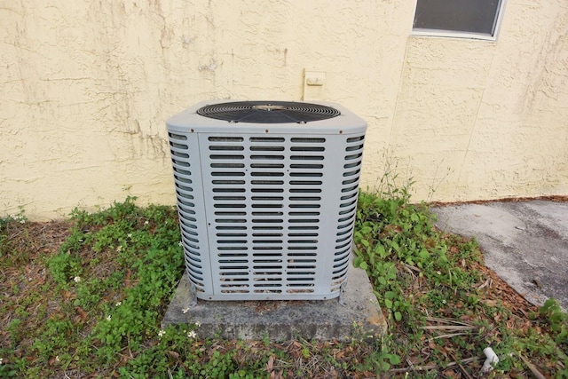 details with central AC unit and stucco siding