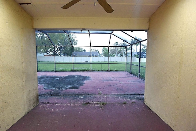 view of patio / terrace featuring glass enclosure, ceiling fan, and fence