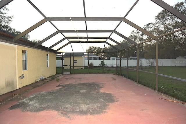 view of patio / terrace featuring a lanai, fence, and a carport