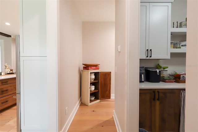 hall featuring recessed lighting, baseboards, and light wood-style floors