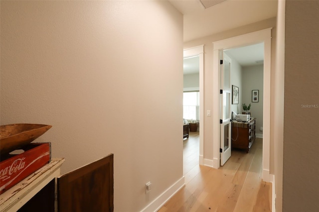 hallway with light wood-style flooring and baseboards