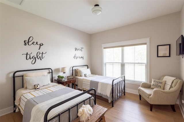 bedroom with light wood-style floors and baseboards