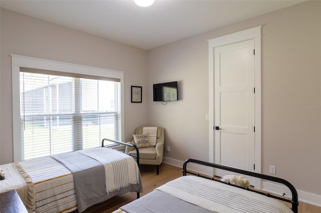 bedroom featuring light wood-style floors and baseboards