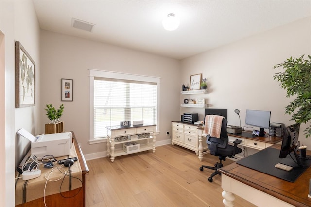 office area with visible vents, light wood-style floors, and baseboards