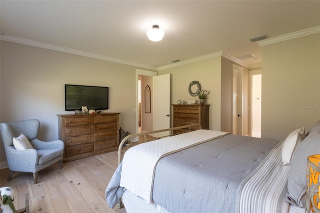 bedroom featuring light wood-style flooring, visible vents, and ornamental molding