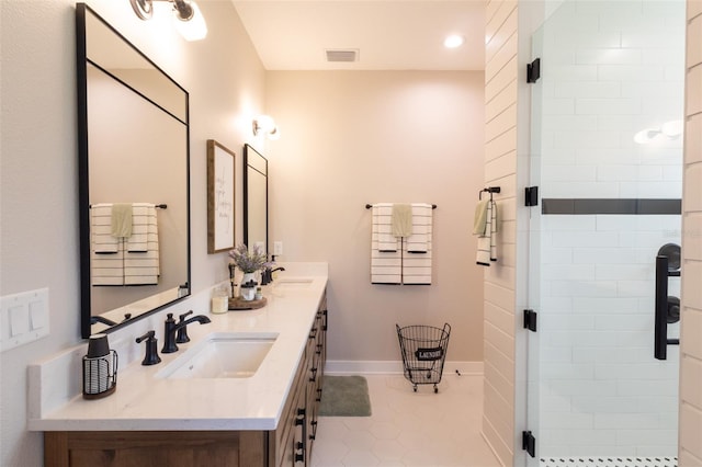 full bathroom with double vanity, visible vents, a stall shower, and a sink