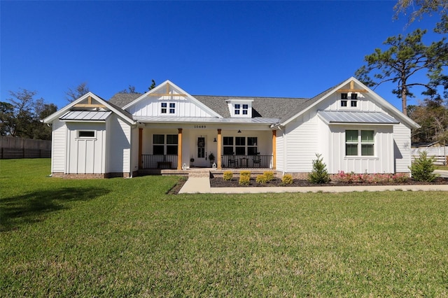 modern farmhouse style home featuring covered porch, board and batten siding, and a front yard