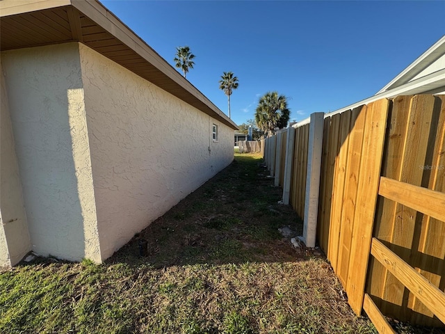 view of property exterior with fence and stucco siding