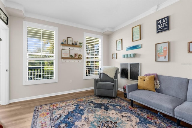 living area featuring baseboards, wood finished floors, and crown molding