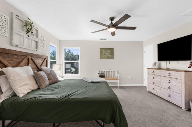 carpeted bedroom featuring visible vents, baseboards, and a ceiling fan