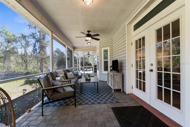 sunroom featuring french doors and a ceiling fan