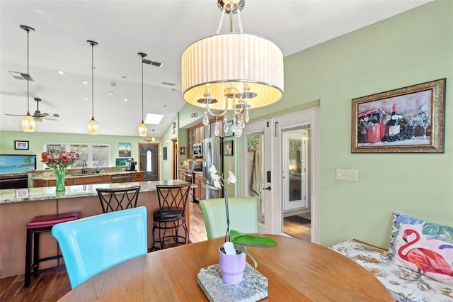 dining room with visible vents, dark wood-style floors, and ceiling fan with notable chandelier