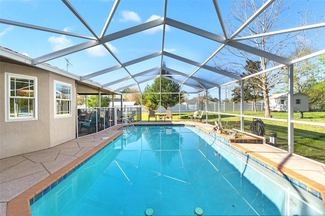 view of pool with a patio, fence, a yard, glass enclosure, and a fenced in pool