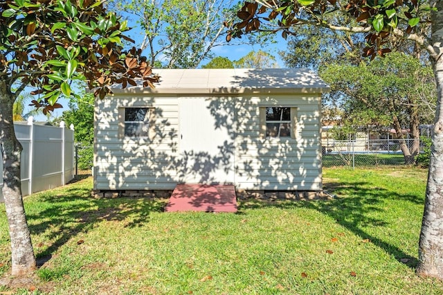 view of side of property with a fenced backyard, a shed, an outdoor structure, and a yard