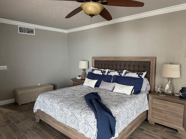 bedroom featuring ornamental molding, wood finish floors, visible vents, and a textured ceiling