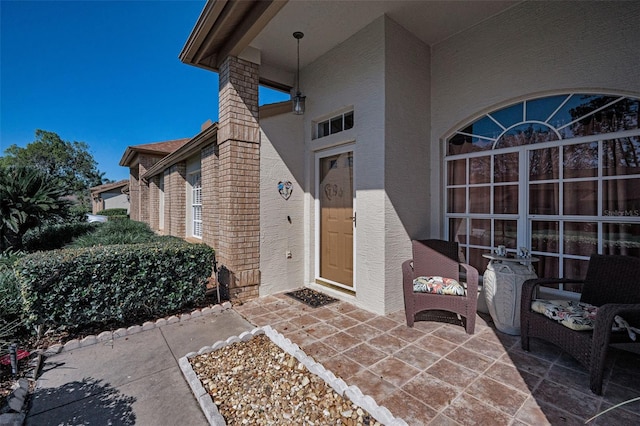 entrance to property featuring a patio area and stucco siding