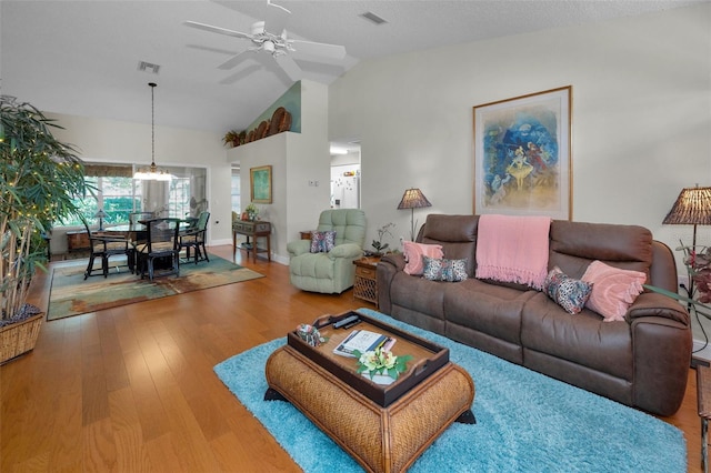 living area featuring ceiling fan, visible vents, baseboards, and wood finished floors