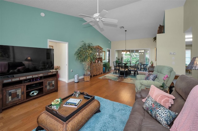 living room with ceiling fan, wood finished floors, a healthy amount of sunlight, and high vaulted ceiling