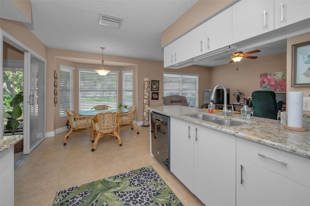 kitchen with visible vents, dishwasher, a textured ceiling, white cabinetry, and a sink