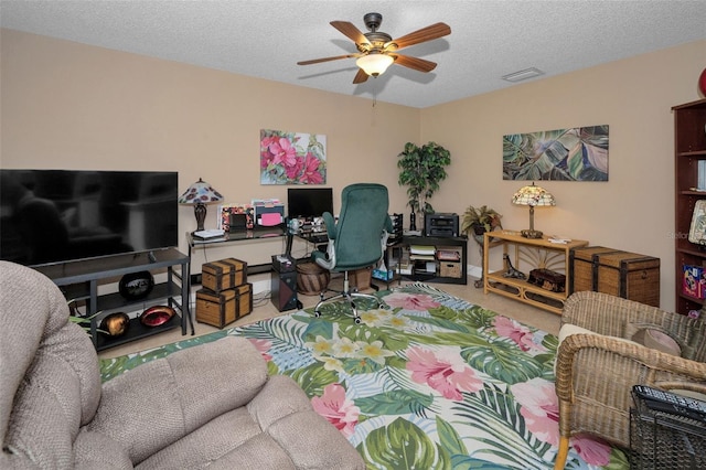 carpeted office space featuring a textured ceiling and a ceiling fan