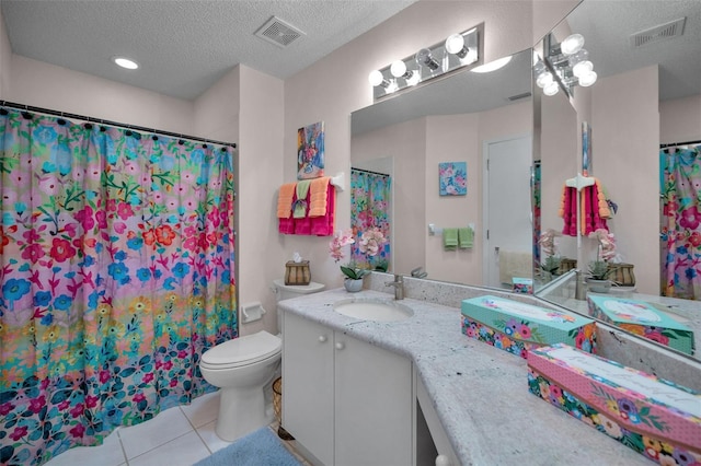 bathroom featuring vanity, tile patterned floors, visible vents, and a textured ceiling