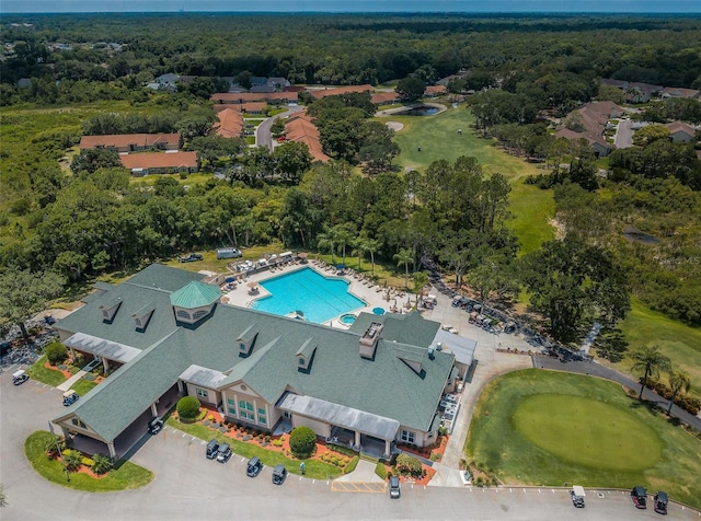 drone / aerial view featuring view of golf course and a wooded view