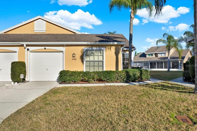 view of front of house with stucco siding, driveway, an attached garage, and a front yard