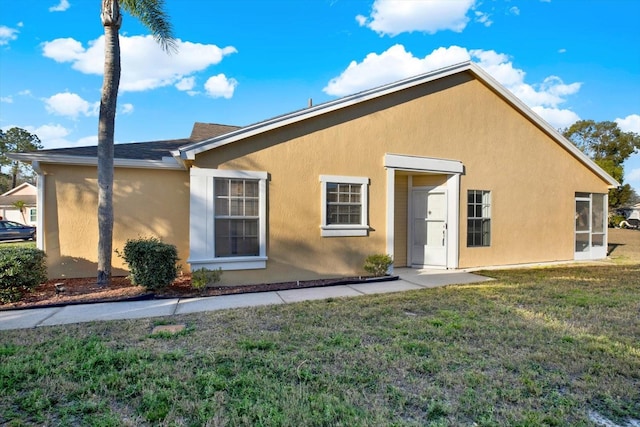 view of front of house featuring stucco siding and a front yard