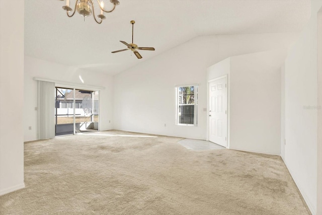 carpeted empty room featuring ceiling fan with notable chandelier and high vaulted ceiling