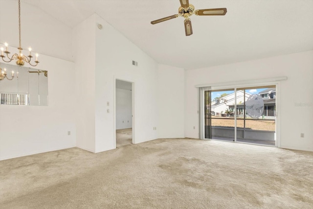 carpeted spare room with ceiling fan with notable chandelier, visible vents, and a towering ceiling