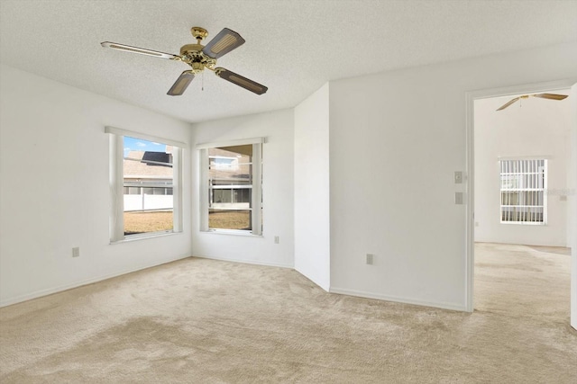 spare room featuring baseboards, carpet, ceiling fan, and a textured ceiling