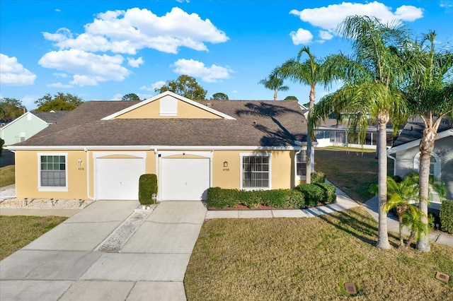 view of front of property with a shingled roof, a front yard, stucco siding, a garage, and driveway