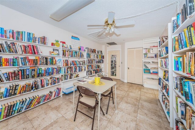 4208 Boston Cir, New Port Richey, FL 34653 - living area with wall of books, ceiling fan, and a textured ceiling