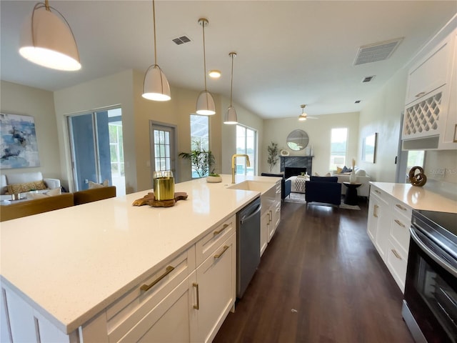 kitchen featuring white cabinetry, stainless steel appliances, visible vents, and open floor plan