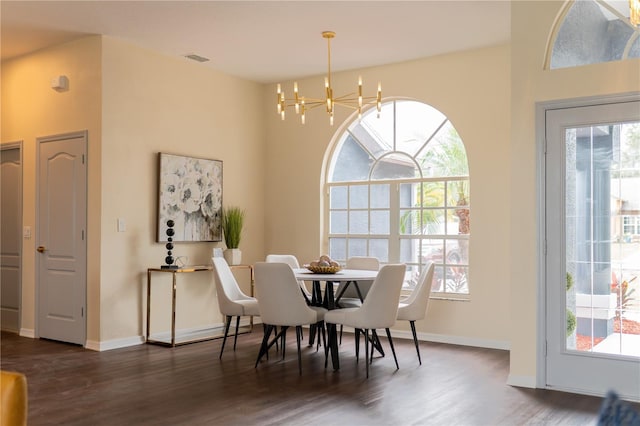 dining room with a wealth of natural light, wood finished floors, baseboards, and an inviting chandelier