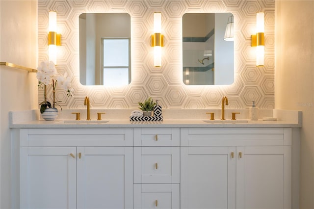 bathroom with double vanity, a shower, and a sink