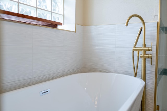 full bath featuring a freestanding tub and tile walls