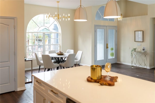 dining space with french doors, dark wood finished floors, a wealth of natural light, and a notable chandelier