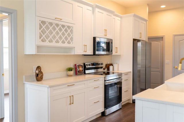 kitchen featuring recessed lighting, stainless steel appliances, dark wood-type flooring, white cabinets, and light countertops