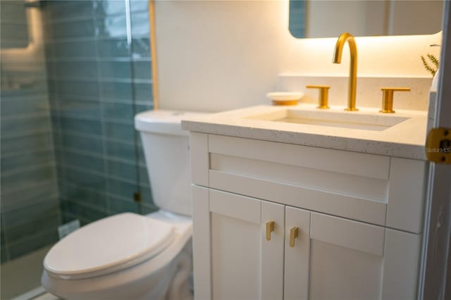 bathroom with a stall shower, vanity, and toilet