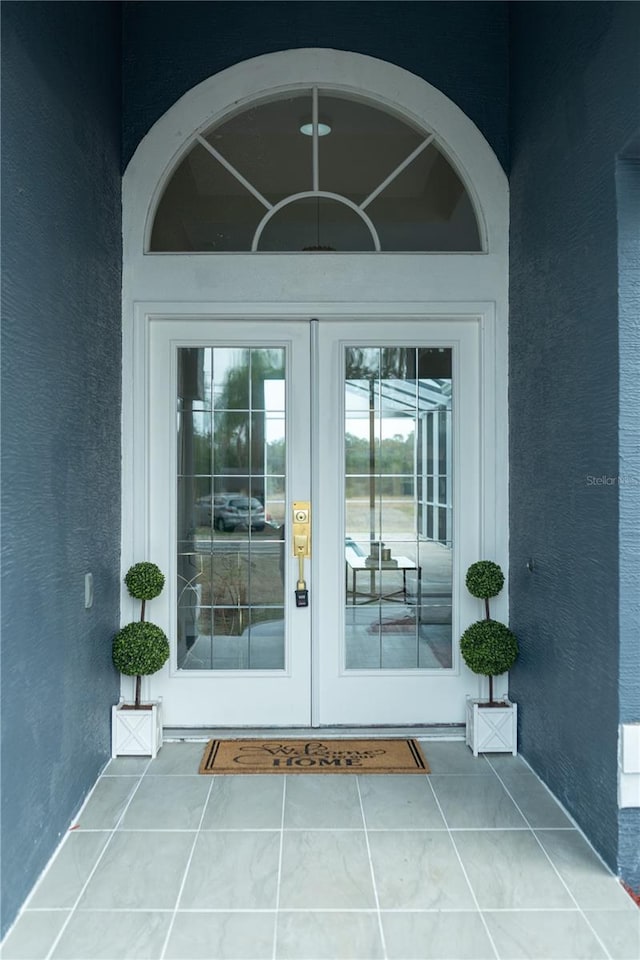 doorway to property featuring french doors and stucco siding